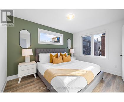 A bedroom with a white bed and a green wall.