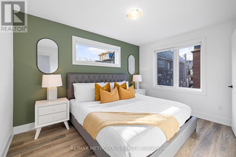A bedroom with a white bed and a green wall.
