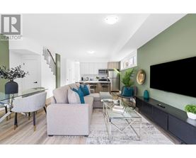 A modern living room with a glass table and grey couch.