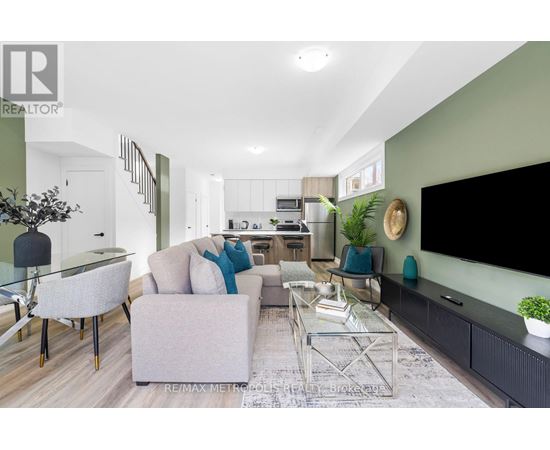 A modern living room with a glass table and grey couch.
