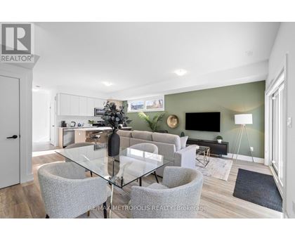 A modern dining room with a glass table and grey chairs.