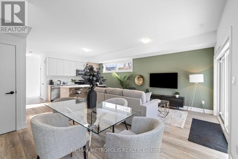 A modern dining room with a glass table and grey chairs.