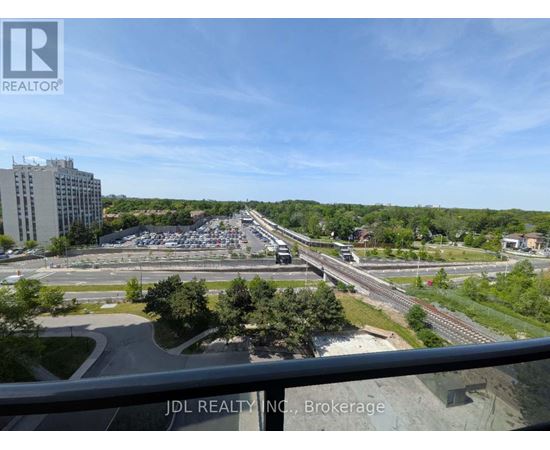 A view from a balcony looking out over a parking lot and highway.