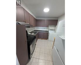 A kitchen with brown cabinets and a black stove top oven.