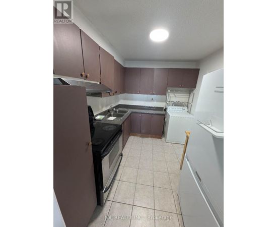 A kitchen with brown cabinets and a black stove top oven.