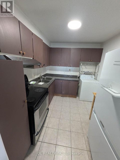 A kitchen with brown cabinets and a black stove top oven.