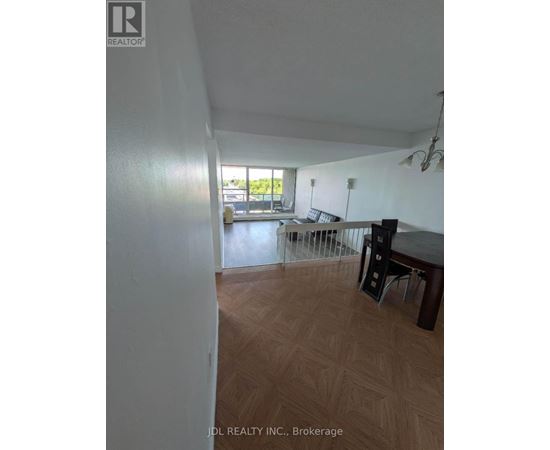 A room with a wooden floor and a table with chairs.