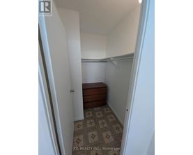 A hallway with a tiled floor and a bench under a window.