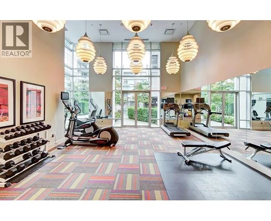A gym with a variety of equipment including weights, treadmills, and exercise bikes.