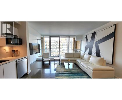 A modern living room with a large couch and a television.