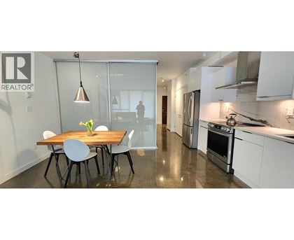 A modern kitchen with a dining table and chairs.