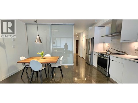 A modern kitchen with a dining table and chairs.