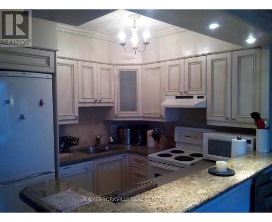 A kitchen with a refrigerator on the left and a microwave on the counter.