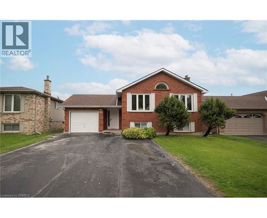 A large red brick house with a driveway in front.