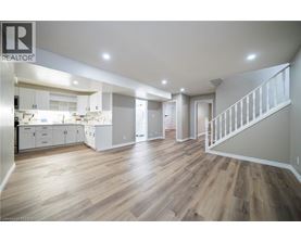 A spacious open plan kitchen and living room with wooden flooring.
