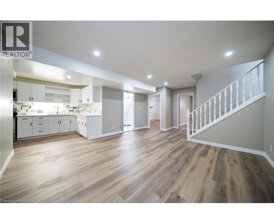 A spacious open plan kitchen and living room with wooden flooring.