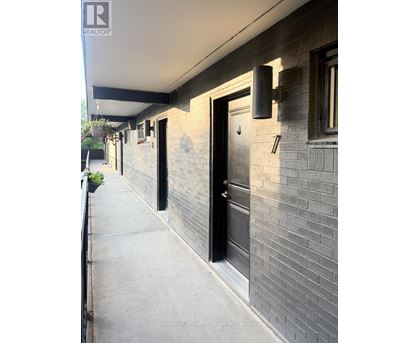 A building with a black door and a window with a white frame.