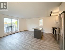 A spacious room with a kitchenette and a view of the outside.