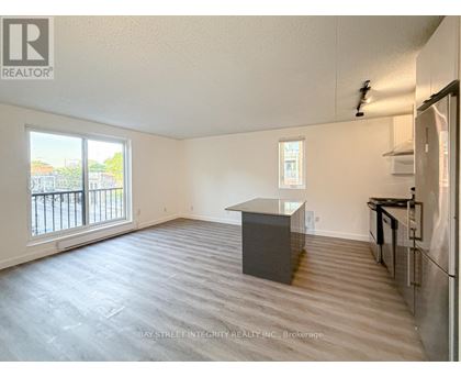A spacious room with a kitchenette and a view of the outside.