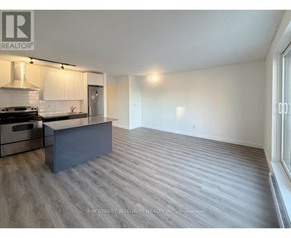 A spacious kitchen with a stove top oven and a refrigerator.