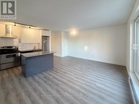 A spacious kitchen with a stove top oven and a refrigerator.