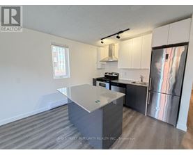 A kitchen with a refrigerator, stove, and sink.