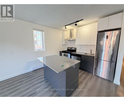 A kitchen with a refrigerator, stove, and sink.