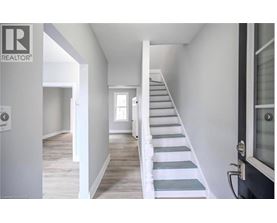 A staircase with white railings leads up to a door.