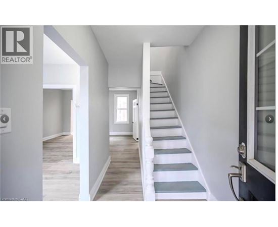 A staircase with white railings leads up to a door.