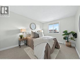 A bedroom with a bed, nightstand, and window.