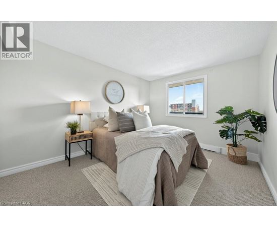 A bedroom with a bed, nightstand, and window.