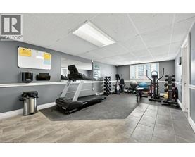A gym room with a treadmill, weights, and exercise balls.