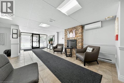 A living room with a grey couch and a stone fireplace.