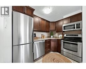 A kitchen with a refrigerator, microwave, oven and stove.