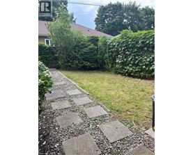 A stone pathway leads through a lush green garden.