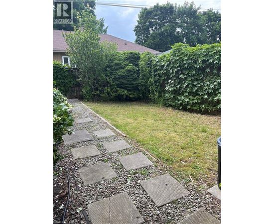 A stone pathway leads through a lush green garden.
