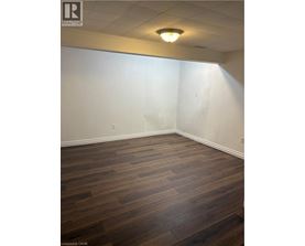 A room with wooden flooring and white walls.