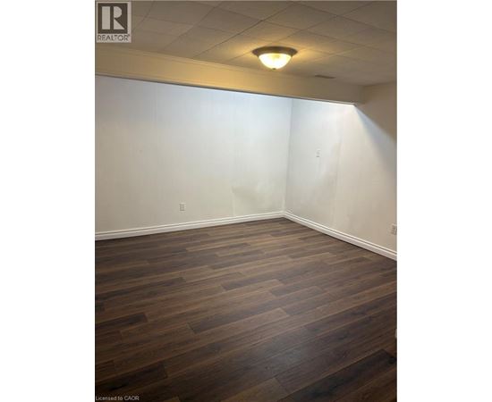 A room with wooden flooring and white walls.