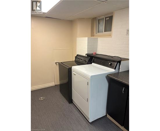 A white dishwasher is in a kitchen with a black counter.