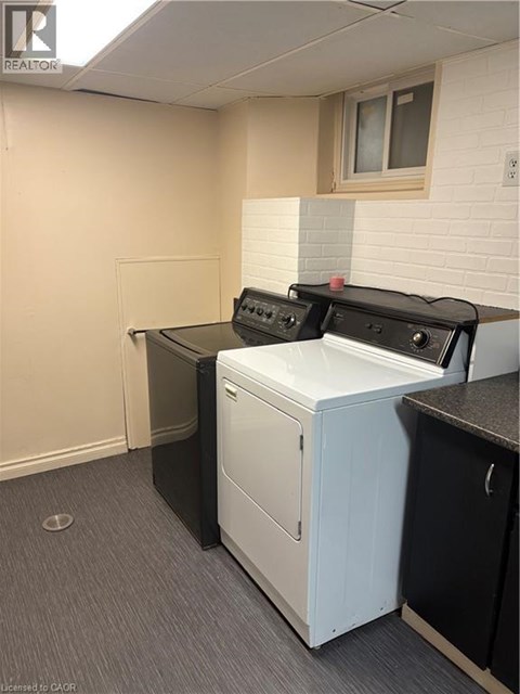 A white dishwasher is in a kitchen with a black counter.