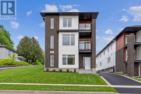 A modern two-story residential building with a well-maintained lawn in front.