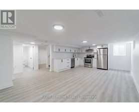 A spacious kitchen with white cabinets and stainless steel appliances.