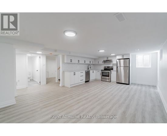 A spacious kitchen with white cabinets and stainless steel appliances.