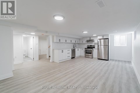 A spacious kitchen with white cabinets and stainless steel appliances.