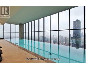 A glass-walled room with a pool and a view of the city.