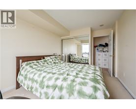 A bedroom with a bed and a mirror on the wall.