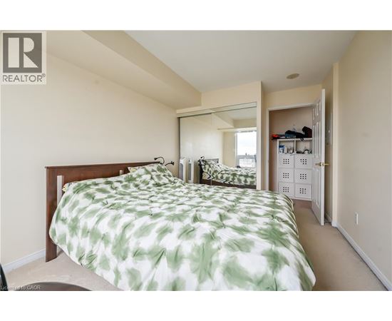 A bedroom with a bed and a mirror on the wall.