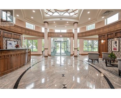 A spacious lobby with a marble floor and a glass ceiling.