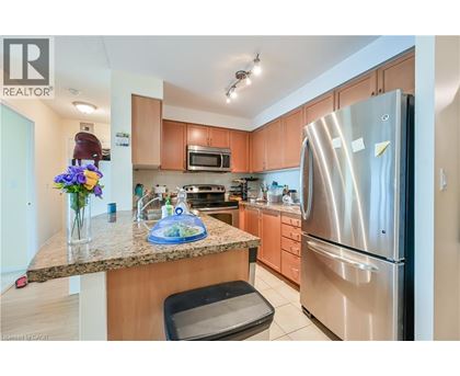 A kitchen with a granite counter top and stainless steel appliances.