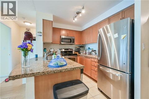 A kitchen with a granite counter top and stainless steel appliances.